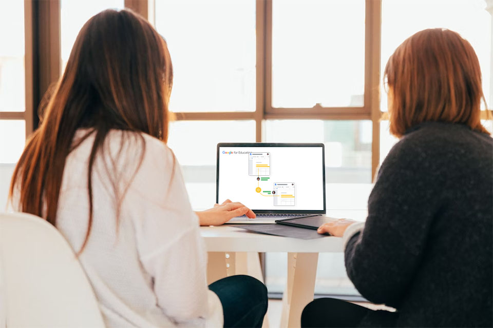 Two female students using Google Workspace for Education on a laptop device