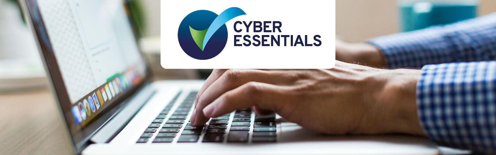 Cyber essentials logo over a man typing on a laptop